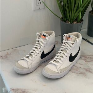 Nike women’s High-Top Sneakers in White with Black Swoosh and Orange Tongue Tag